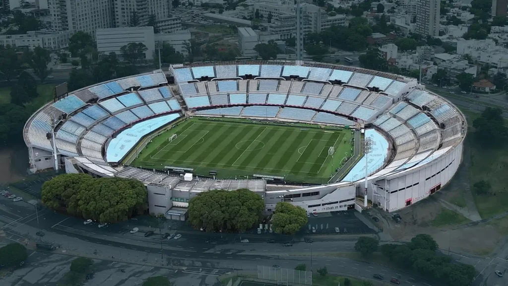 Drone-style top view of Estadio Centenario, Montevideo — the historic site of the first FIFA World Cup, nestled in the city landscape.
